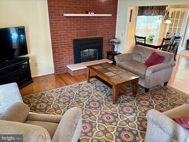 living room featuring a fireplace, brick wall, and wood-type flooring