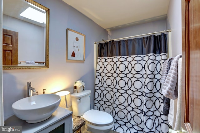 bathroom with a shower with shower curtain, vanity, and toilet