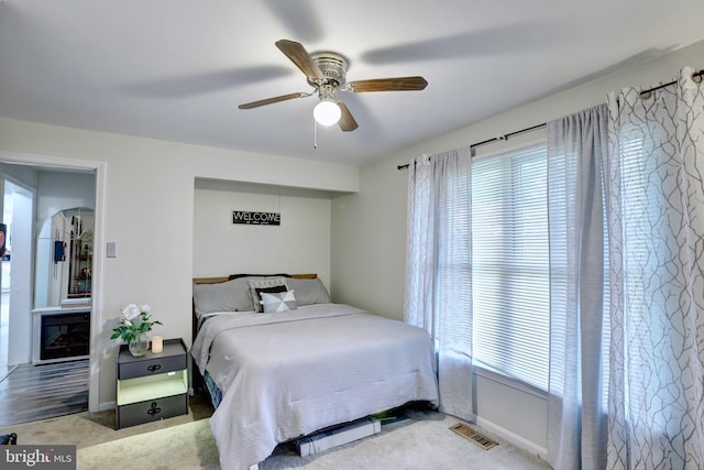 bedroom with ceiling fan, carpet, and multiple windows