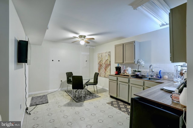 kitchen featuring ceiling fan, sink, backsplash, and light tile patterned floors