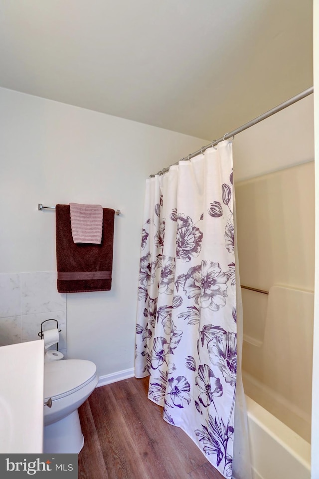 full bathroom with hardwood / wood-style flooring, shower / bath combination with curtain, toilet, and vanity