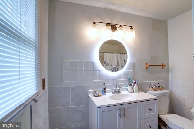 bathroom featuring toilet, decorative backsplash, vanity, and tile walls