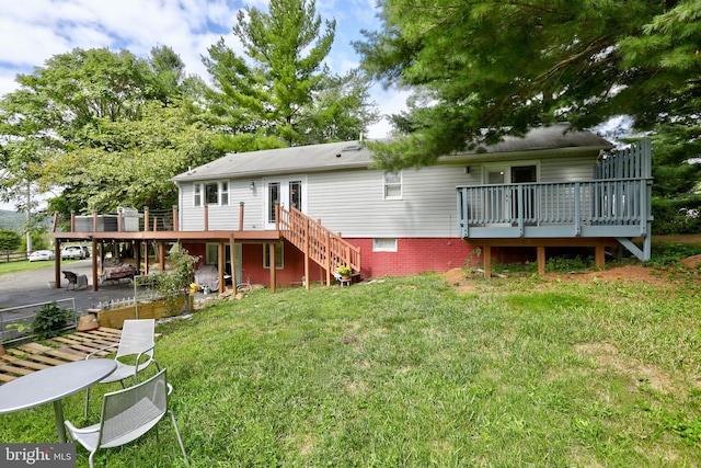 rear view of house featuring a deck and a lawn