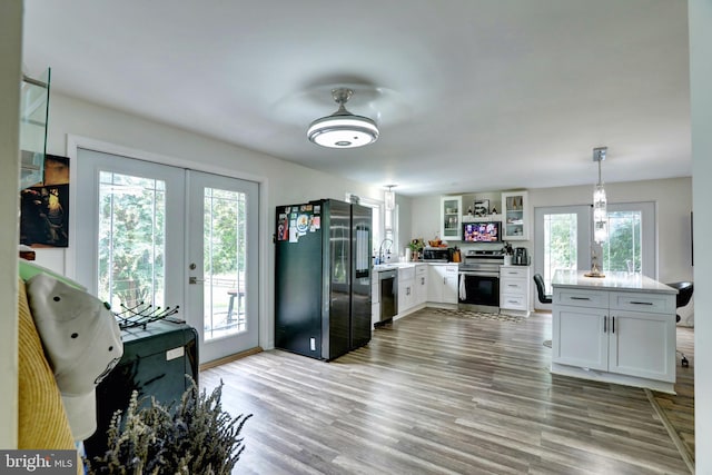 kitchen featuring plenty of natural light, light hardwood / wood-style flooring, white cabinetry, and stainless steel appliances