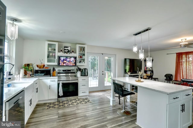 kitchen with light hardwood / wood-style floors, electric stove, french doors, and white cabinetry