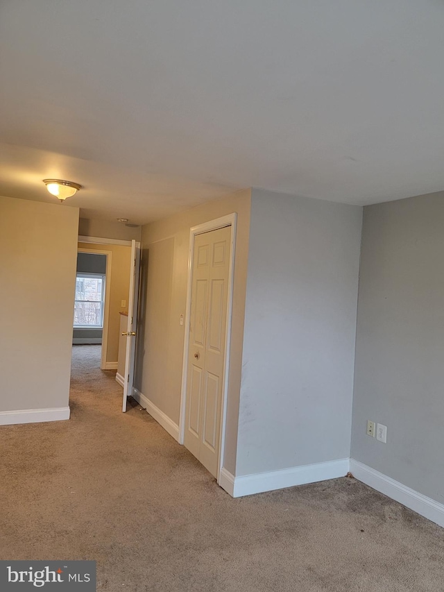 interior space with light colored carpet and baseboards