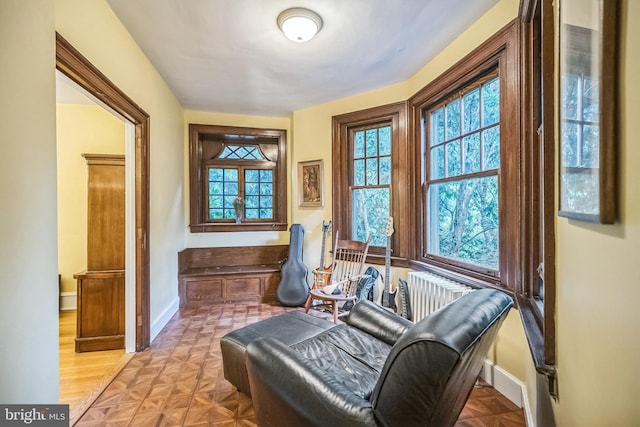 living area featuring parquet flooring and radiator heating unit