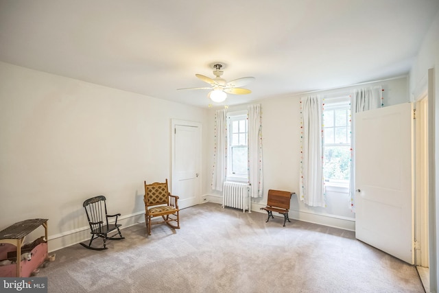 unfurnished room featuring ceiling fan, radiator, and light carpet