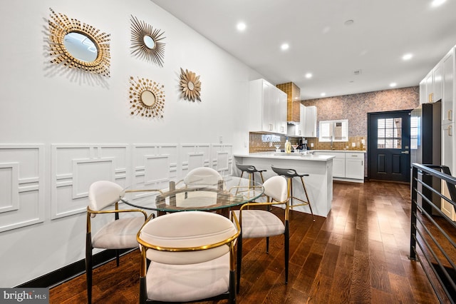 dining area with dark wood-type flooring, recessed lighting, and wainscoting