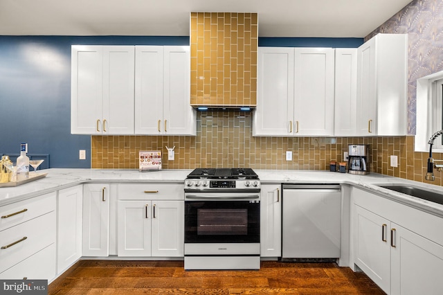 kitchen featuring stainless steel appliances, white cabinetry, dark hardwood / wood-style floors, sink, and light stone countertops