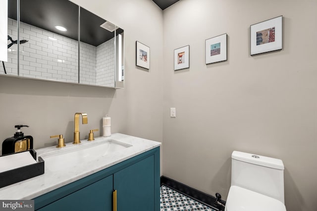 bathroom with tile patterned flooring, toilet, vanity, and walk in shower