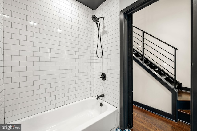 bathroom with hardwood / wood-style flooring and tiled shower / bath