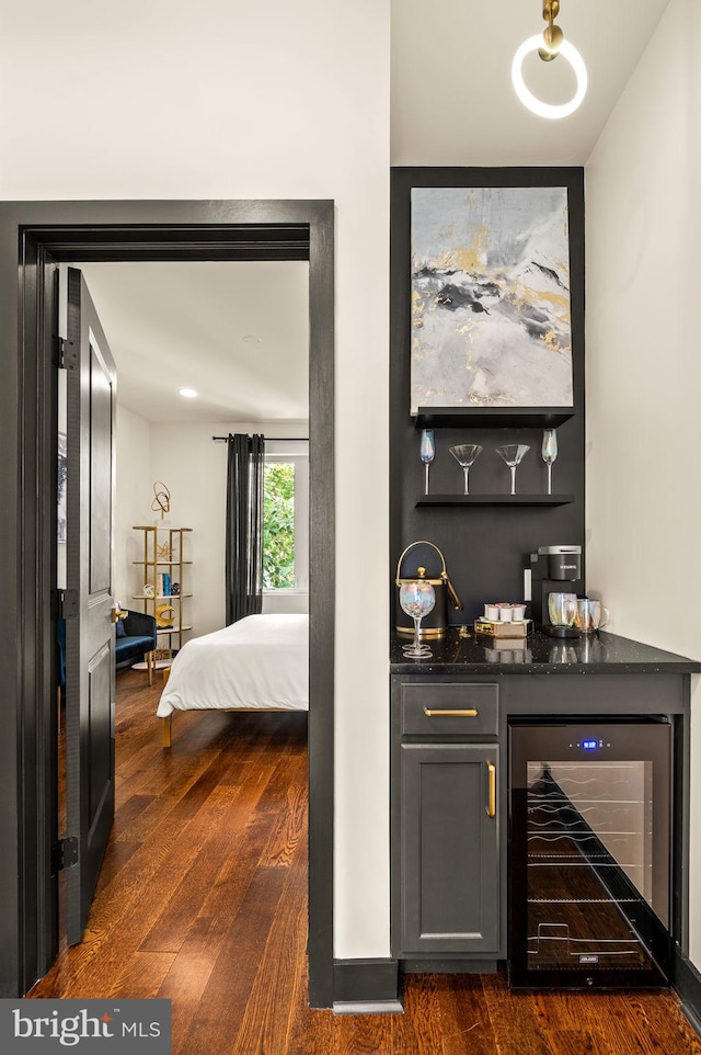 bar with wine cooler and dark hardwood / wood-style floors