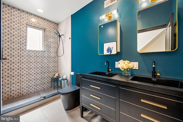 bathroom with toilet, tiled shower, vanity, and tile patterned floors