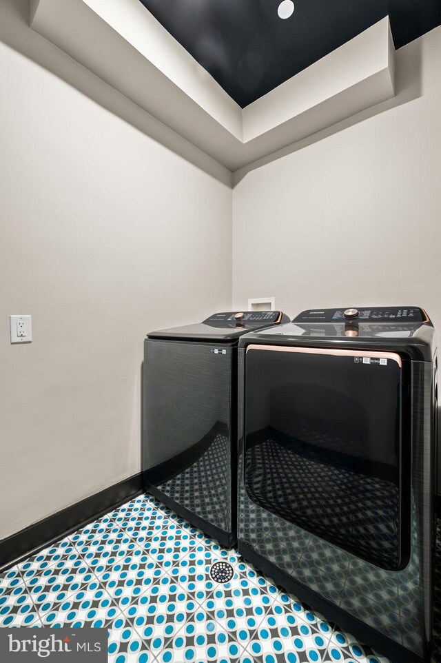 laundry room with washer and clothes dryer, wood-type flooring, and a barn door