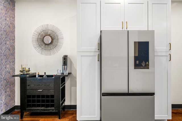 interior space featuring wood-type flooring and stainless steel refrigerator