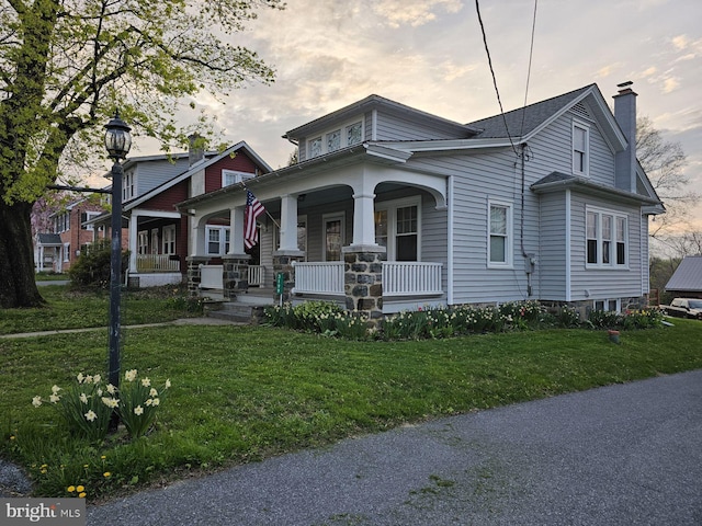 view of front of home with a yard and covered porch