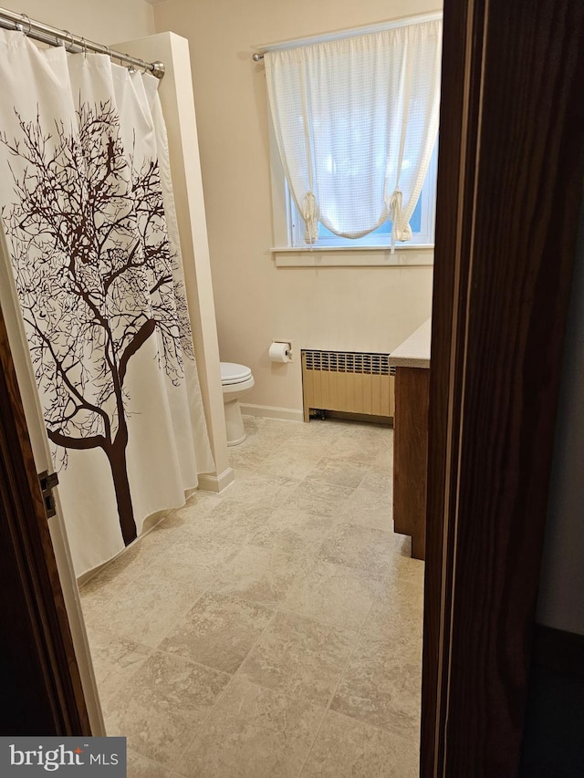 bathroom featuring vanity, toilet, and radiator heating unit