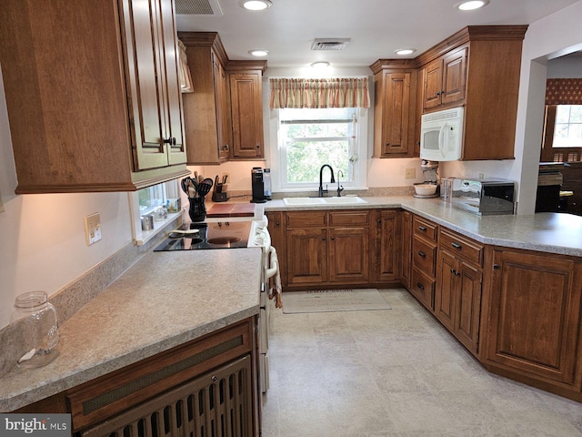 kitchen featuring stove, sink, and a healthy amount of sunlight