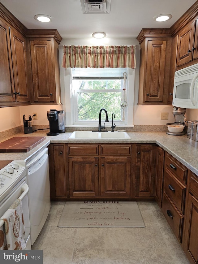 kitchen featuring light tile patterned flooring, white appliances, and sink