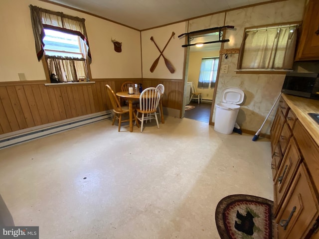 dining space with ornamental molding, wainscoting, and a baseboard radiator