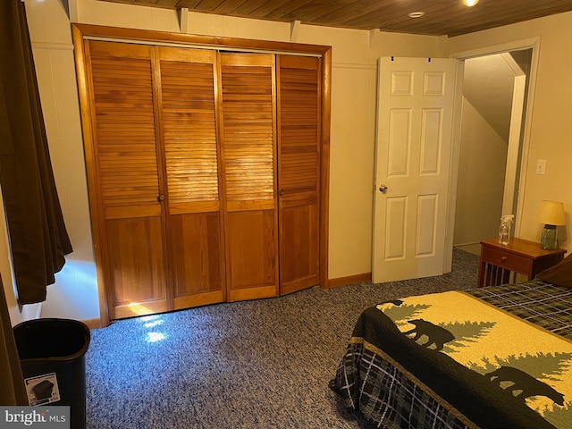 carpeted bedroom featuring a closet and wood ceiling