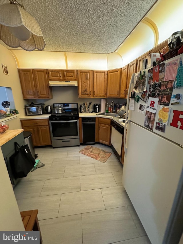 kitchen featuring light tile patterned flooring, white appliances, a textured ceiling, and sink