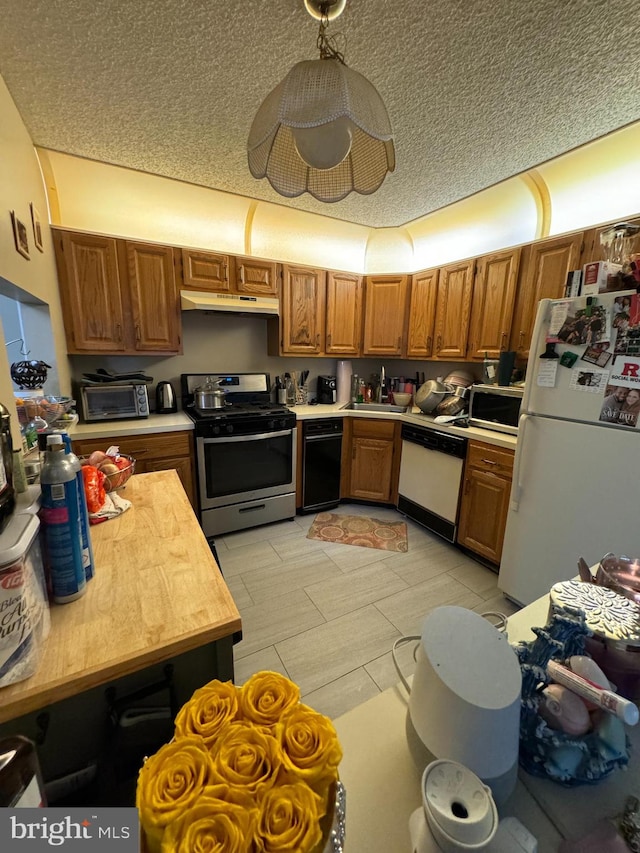 kitchen with stainless steel appliances, sink, and a textured ceiling