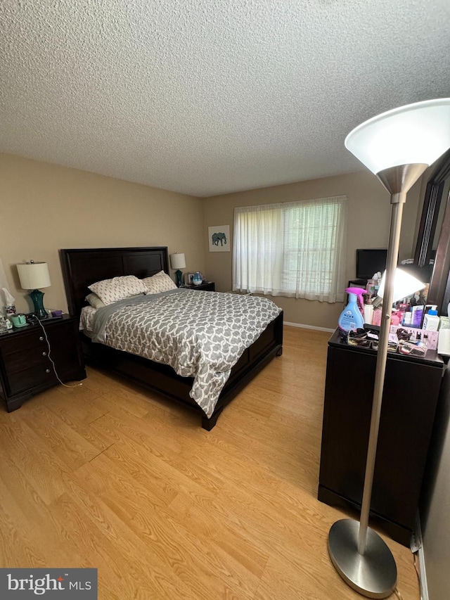 bedroom featuring hardwood / wood-style flooring and a textured ceiling