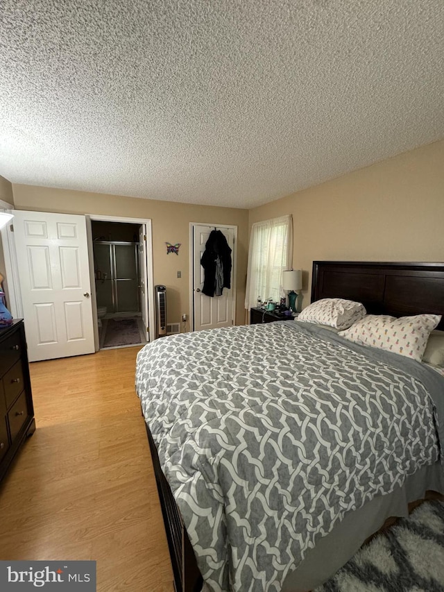 bedroom with light wood-type flooring and a textured ceiling