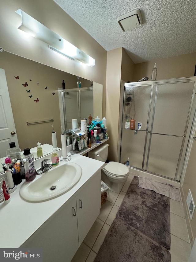 bathroom with tile patterned flooring, toilet, a shower with door, and vanity