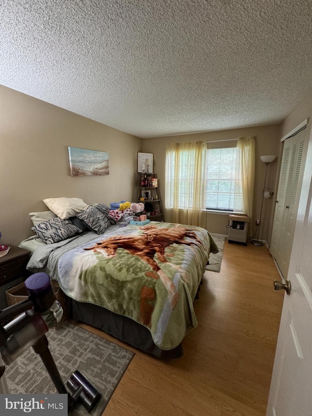 bedroom featuring a textured ceiling, a closet, and hardwood / wood-style flooring