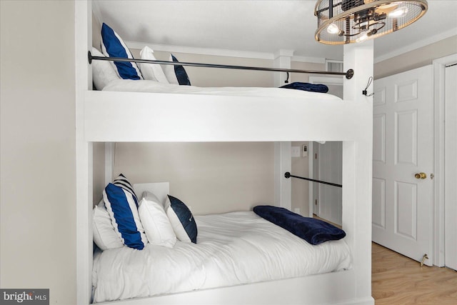 bedroom featuring crown molding and light wood-type flooring