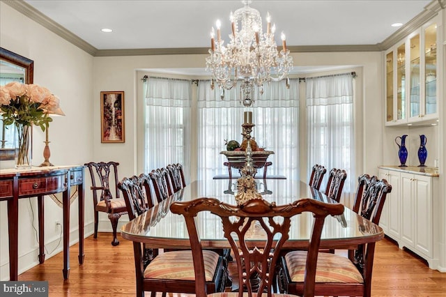 dining space featuring a chandelier, recessed lighting, crown molding, and light wood finished floors