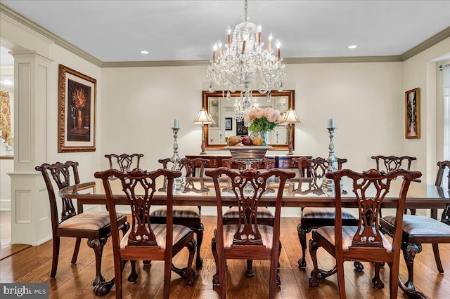 dining room with ornamental molding, recessed lighting, ornate columns, and wood finished floors