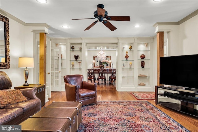 living room with ornamental molding, decorative columns, and wood finished floors