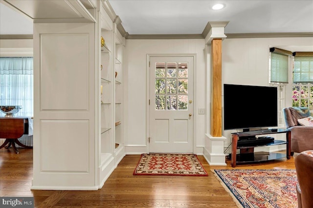 foyer featuring dark wood-style floors, crown molding, and a healthy amount of sunlight