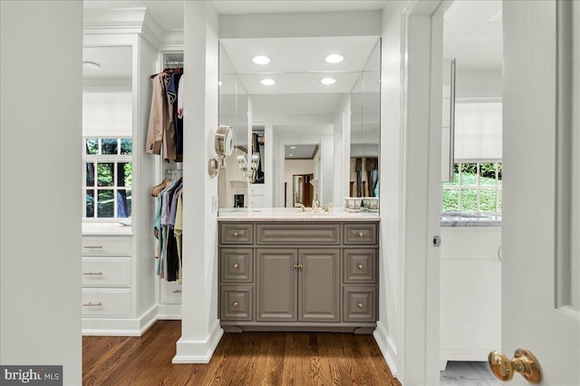 bathroom featuring recessed lighting, wood finished floors, vanity, and a healthy amount of sunlight