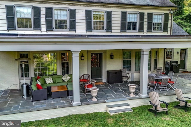 exterior space featuring a patio, outdoor dining area, brick siding, a shingled roof, and an outdoor living space