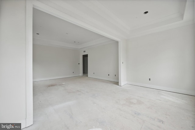 empty room with baseboards, a tray ceiling, and ornamental molding