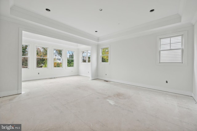 empty room with baseboards, a raised ceiling, and crown molding