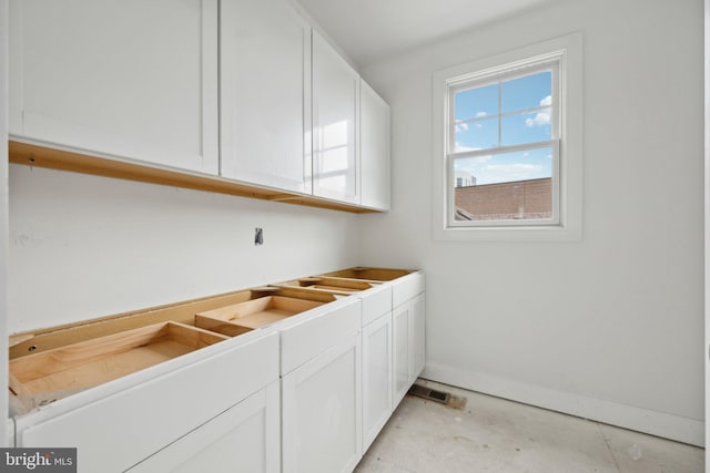 laundry area with baseboards