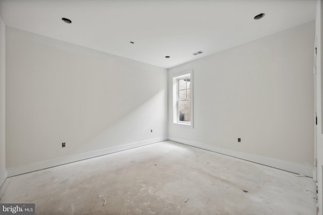 empty room with baseboards, unfinished concrete floors, and visible vents