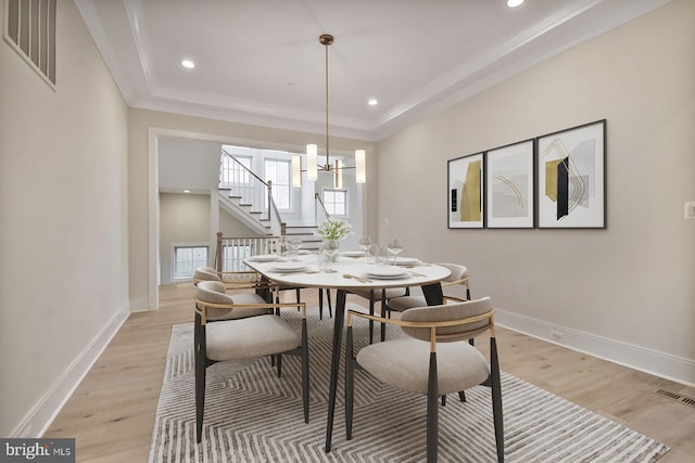 dining room featuring light wood finished floors, visible vents, and baseboards