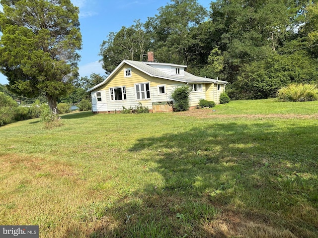 exterior space featuring a lawn and a chimney