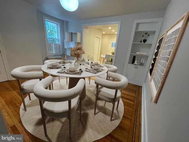 dining area featuring hardwood / wood-style floors and built in shelves