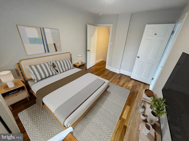 bedroom featuring wood finished floors and baseboards