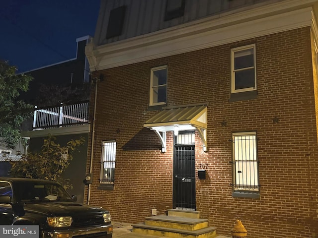 property entrance with brick siding and board and batten siding