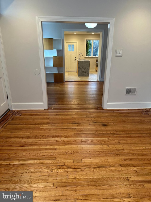 interior space with visible vents, wood finished floors, and baseboards