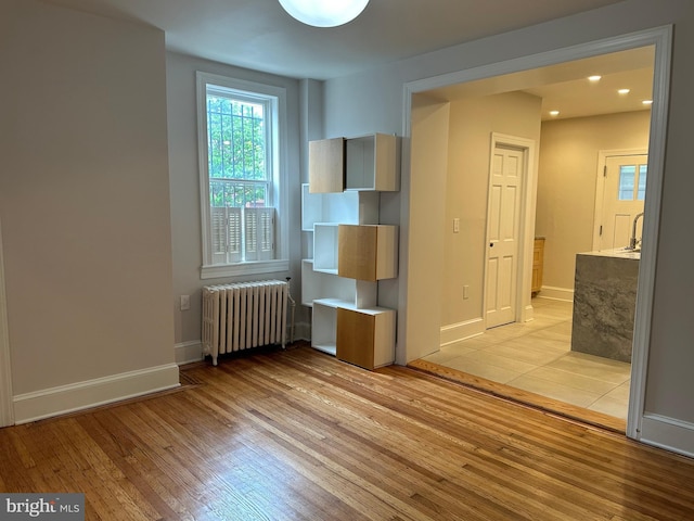 interior space featuring recessed lighting, radiator, light wood-style floors, and baseboards